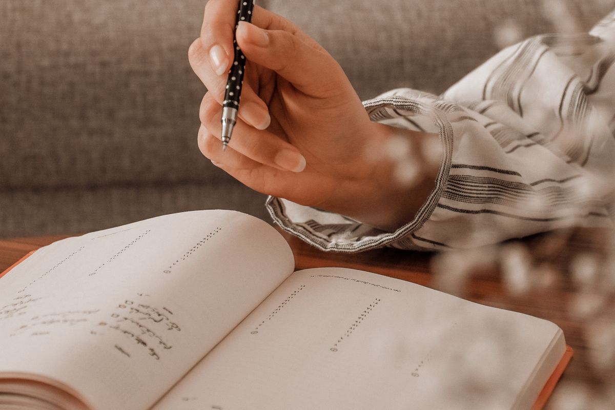 A person writing notes in a planner