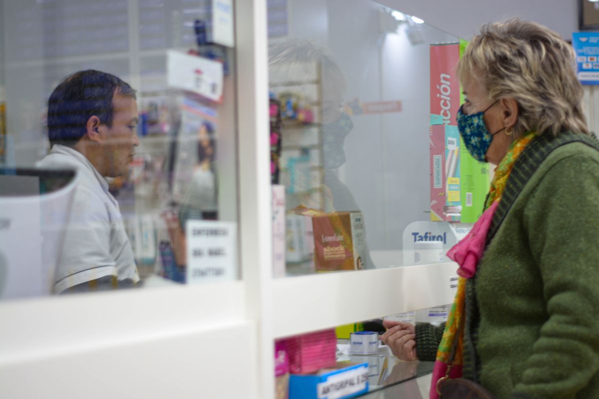 A customer speaking with a pharmacist at a pharmacy counter